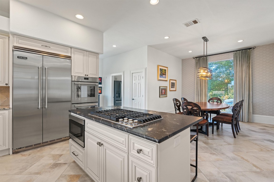 5706 Long Court Austin, TX 78730 - Photo 17 of 40 a kitchen with stainless steel appliances granite countertop a stove a refrigerator and a dining table