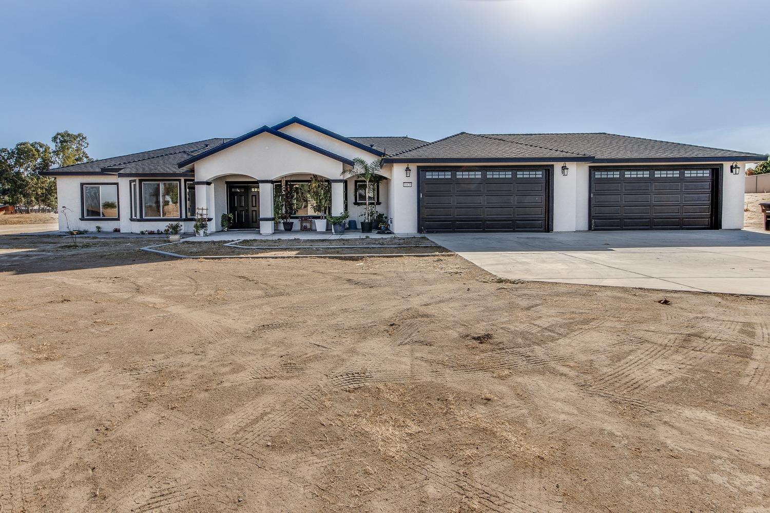 a front view of a house with yard and parking