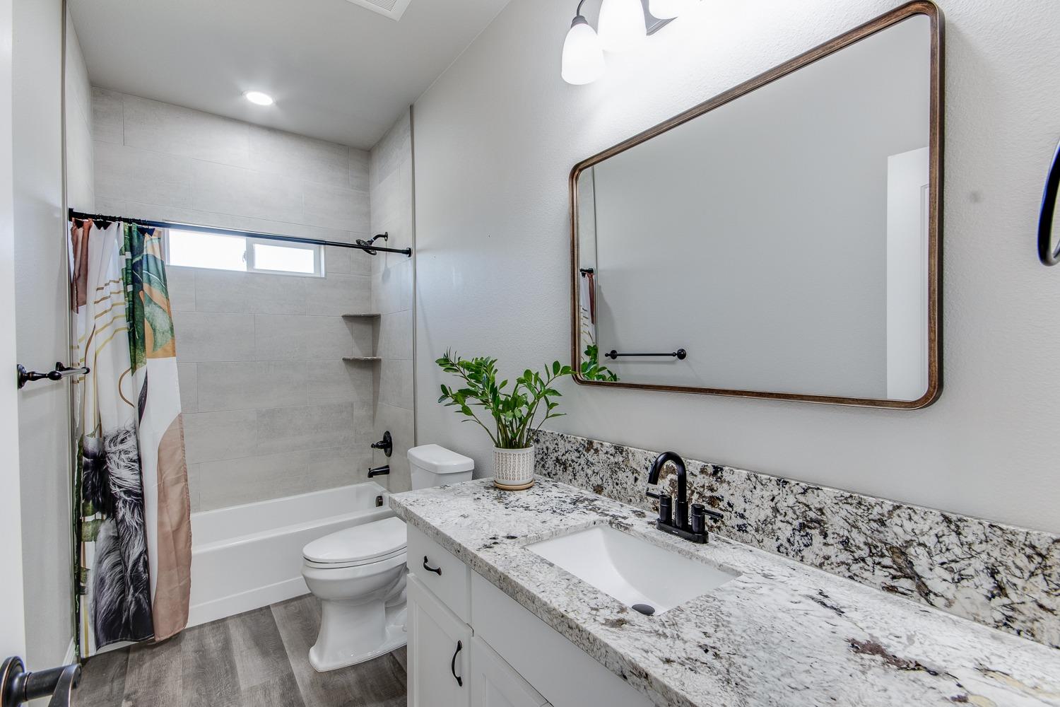 16639 Mark Road Madera, CA 93636 - Photo 13 of 33 a bathroom with a granite countertop sink a toilet and shower