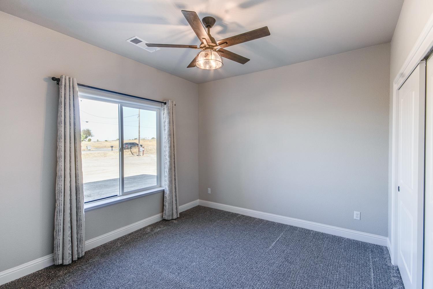 16639 Mark Road Madera, CA 93636 - Photo 17 of 33 an empty room with a window and a ceiling fan