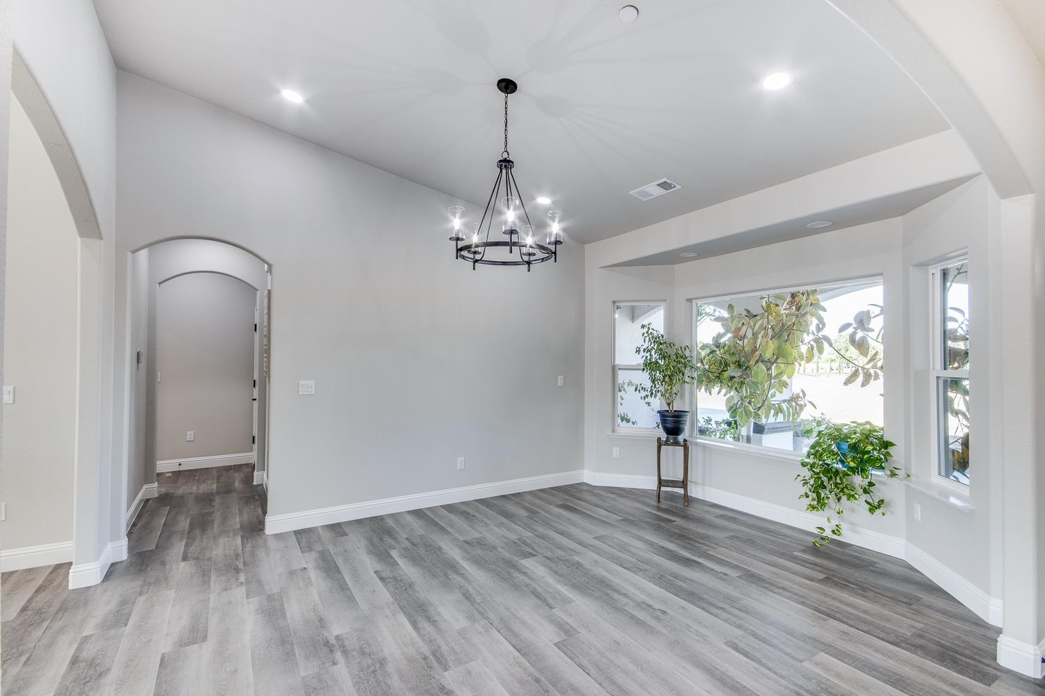 16639 Mark Road Madera, CA 93636 - Photo 5 of 33 a view of a room with wooden floor potted plant and a chandelier