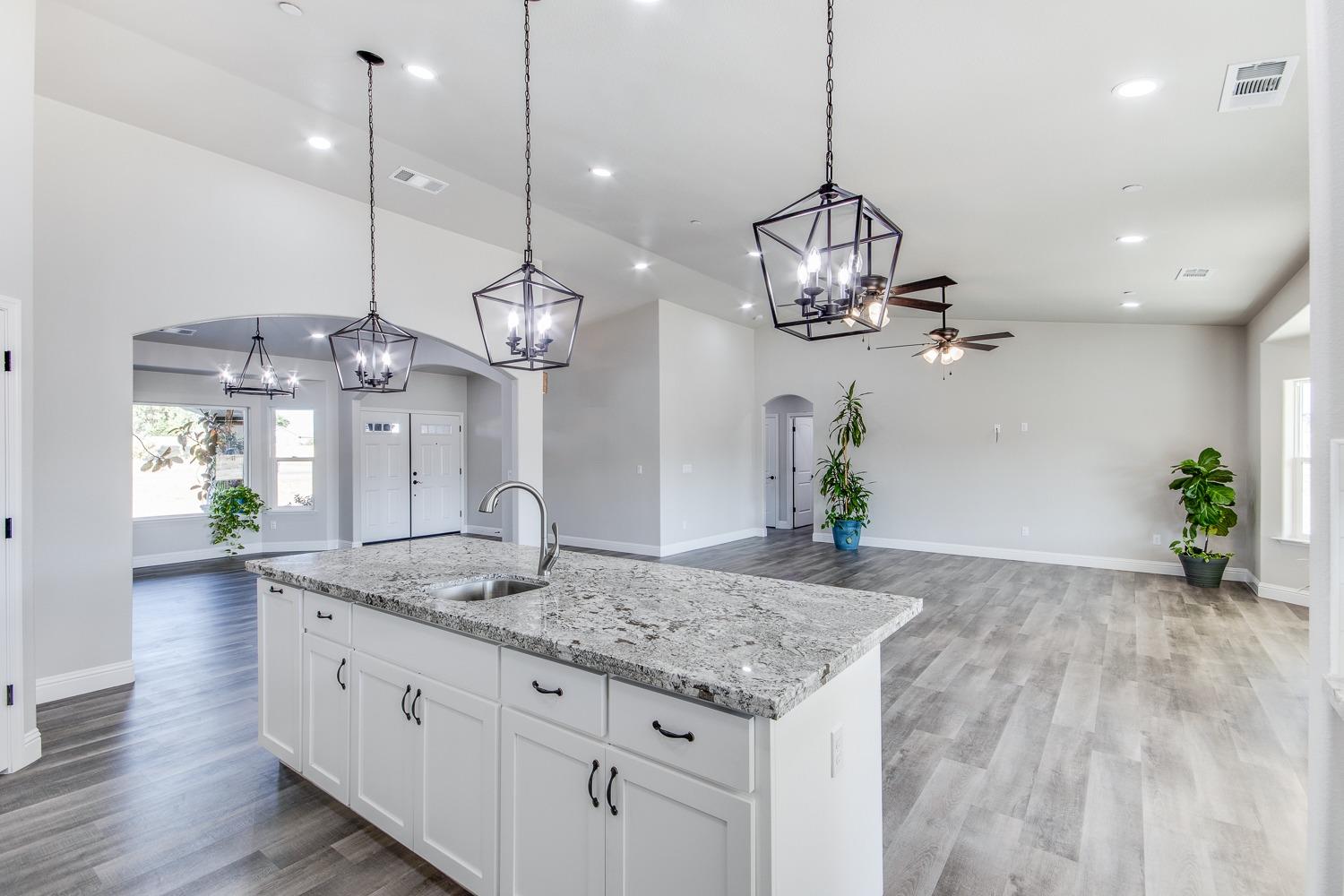 16639 Mark Road Madera, CA 93636 - Photo 8 of 33 a kitchen with granite countertop cabinets a sink and a chandelier