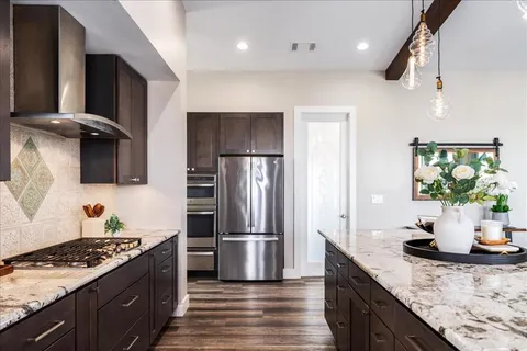 a kitchen with stainless steel appliances granite countertop a sink stove and refrigerator