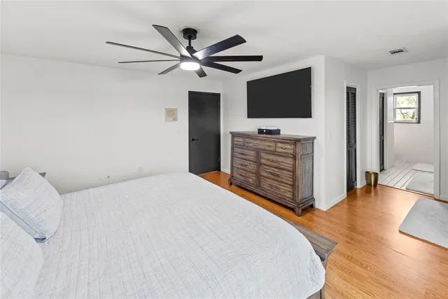 a bedroom with a bed a flat screen tv and a couch