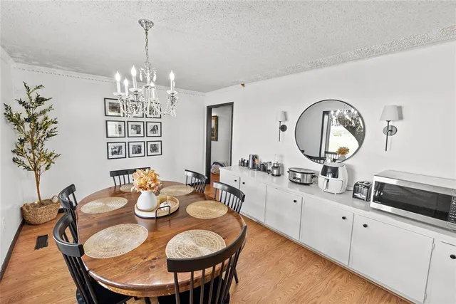 a view of a dining room with furniture a chandelier and wooden floor
