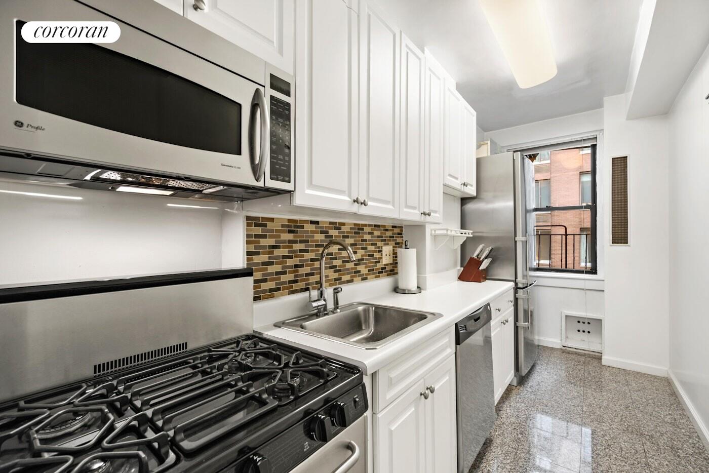 142 East 49th Street, Unit 9E Manhattan, NY 10017 - Photo 2 of 6 a kitchen with a stove and a microwave