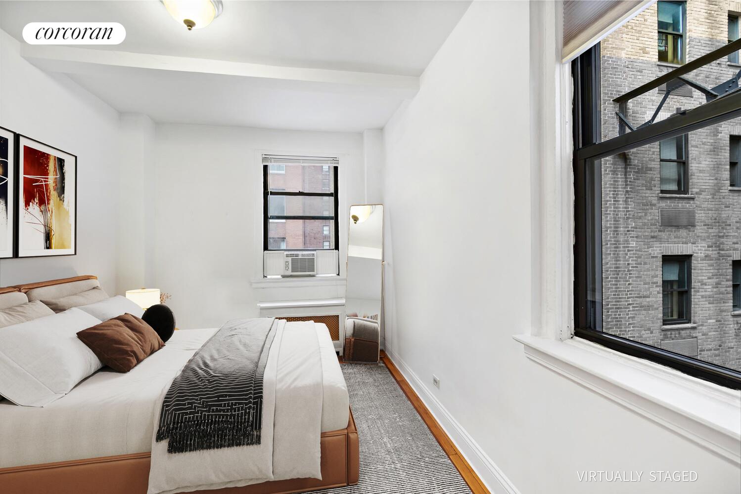 142 East 49th Street, Unit 9E Manhattan, NY 10017 - Photo 4 of 6 a bedroom with a bed and a window