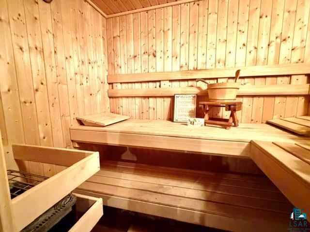 1804 North Bay Road Ely, MN 55731 - Photo 24 of 41 Dedicated sauna room with light wood paneling, multi-level benches, and an integrated sauna heater