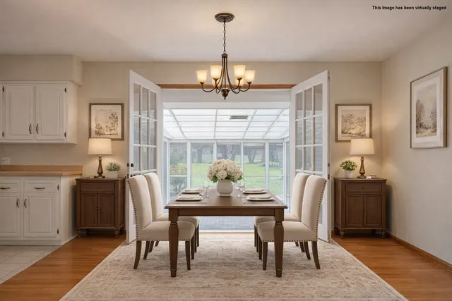 a dining room with furniture a chandelier and wooden floor