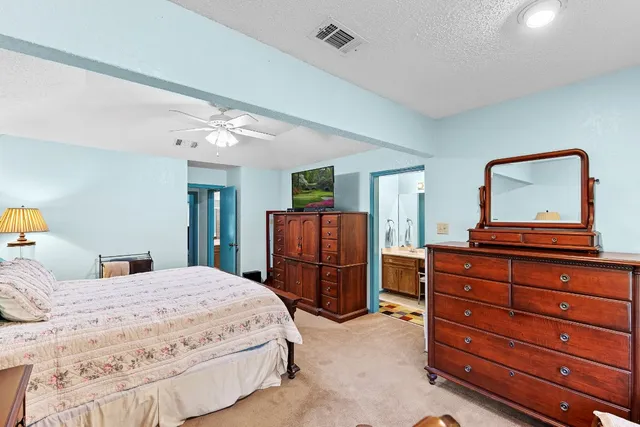 a bedroom with a bed and dresser with mirror