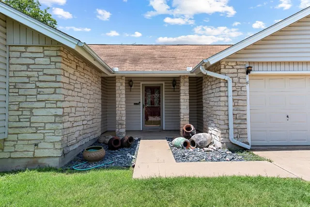 a view of a house with backyard and sitting area