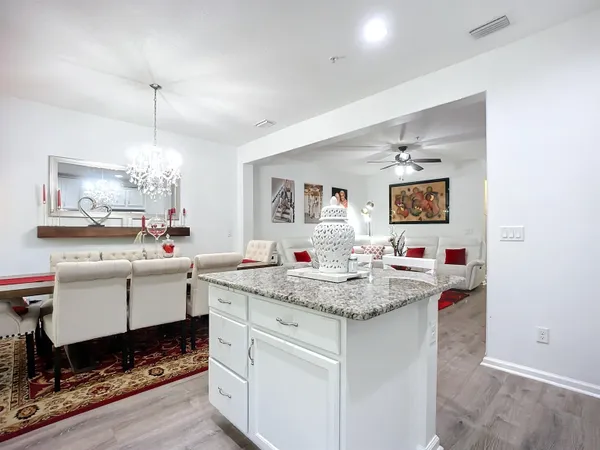 a room with kitchen island a sink and a chandelier