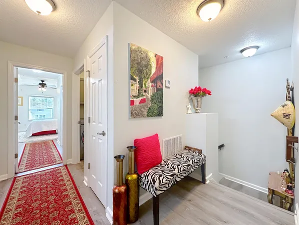 a view of a hallway with bed and wooden floor