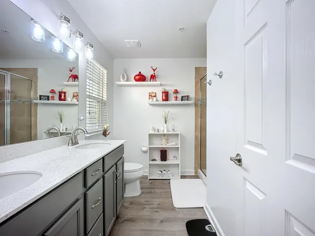 a bathroom with a sink vanity mirror and toilet