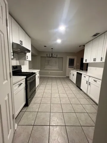 a kitchen with stainless steel appliances a sink a stove a microwave and cabinets