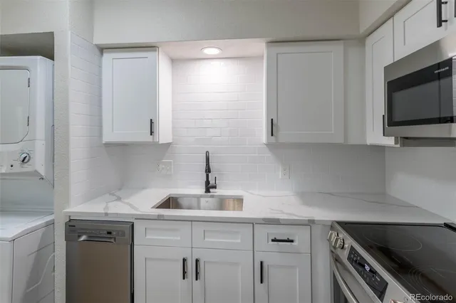 a kitchen with stainless steel appliances white cabinets and a stove top oven