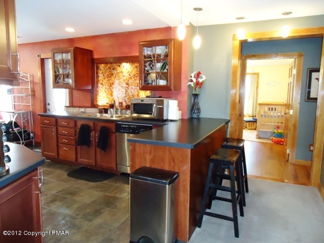 1415 Davids Road Effort, PA 18330 - Photo 9 of 35 a kitchen with stainless steel appliances granite countertop table chairs sink and window