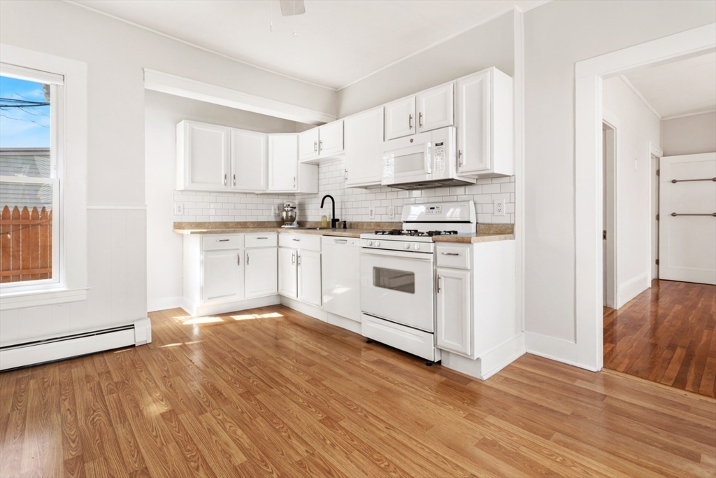 52 Chestnut Street Wakefield, MA 01880 - Photo 29 of 42 a kitchen with stainless steel appliances granite countertop a stove top oven a sink and white cabinets with wooden floor