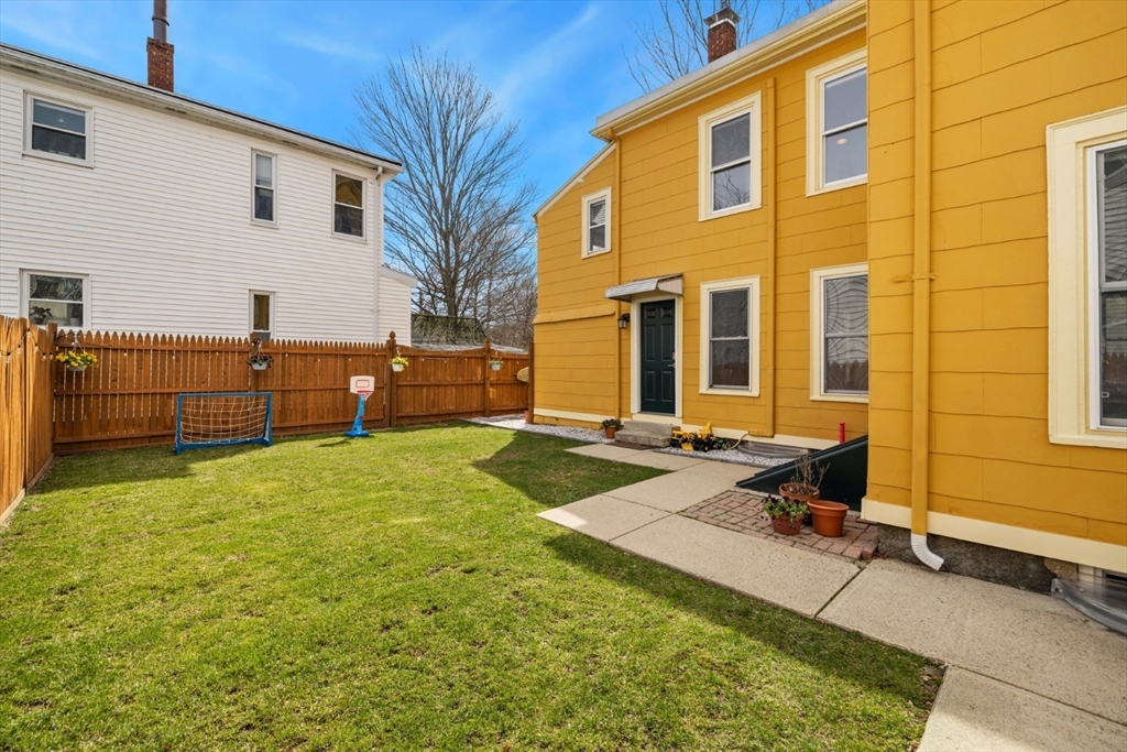 52 Chestnut Street Wakefield, MA 01880 - Photo 38 of 42 a view of backyard with a table and chairs and wooden fence