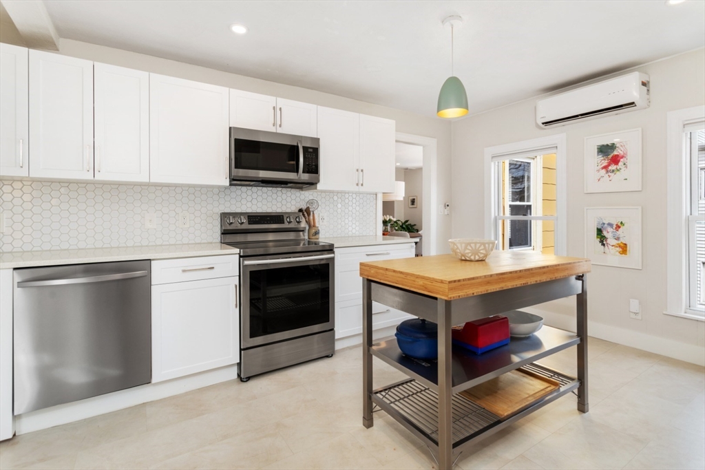 52 Chestnut Street Wakefield, MA 01880 - Photo 5 of 42 a kitchen with kitchen island granite countertop a stove top oven a sink dishwasher and a microwave with wooden floor