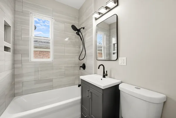 a bathroom with a toilet sink and mirror
