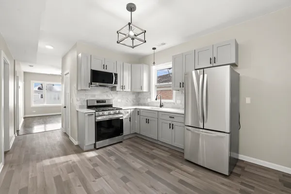 a kitchen with stainless steel appliances a refrigerator a stove top oven a sink and dishwasher