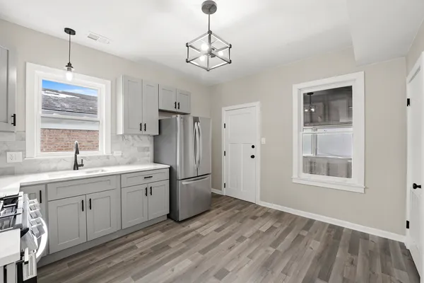a view of a kitchen with a sink dishwasher a refrigerator and wooden floor