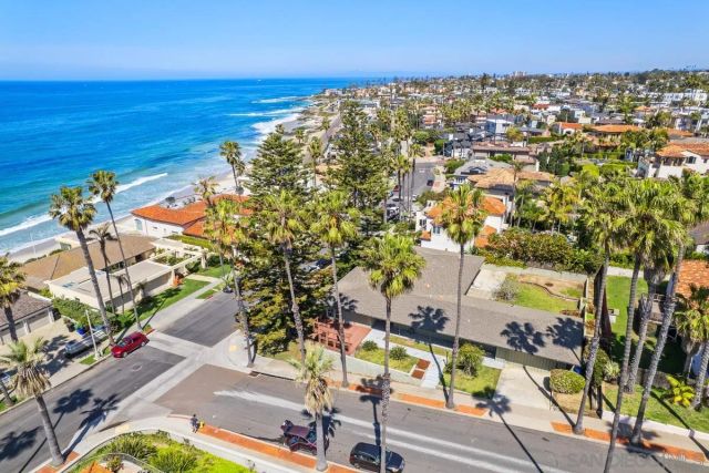 an aerial view of residential houses with outdoor space and parking