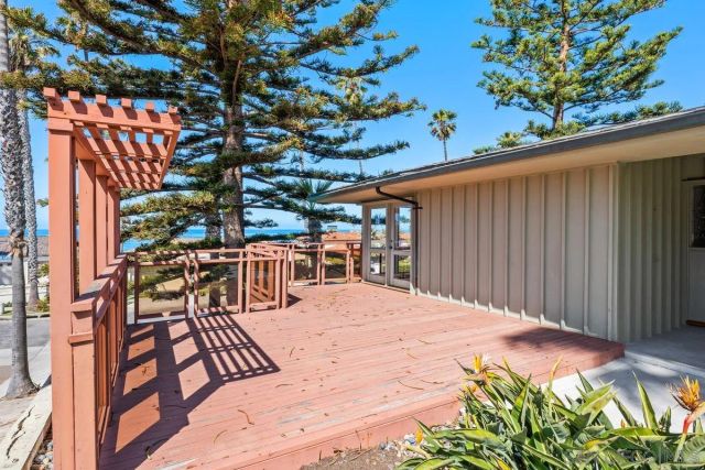 a view of a hallway with wooden floor and a bathroom