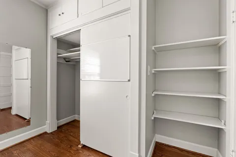 a room with walk in closet and wooden floor
