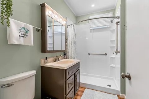 a bathroom with a sink a toilet and shower
