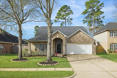 a front view of a house with a garden and trees