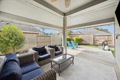 a living room with furniture a flat screen tv and a floor to ceiling window