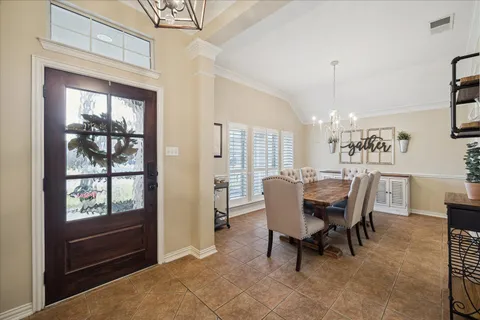 a dining room with furniture a chandelier and window