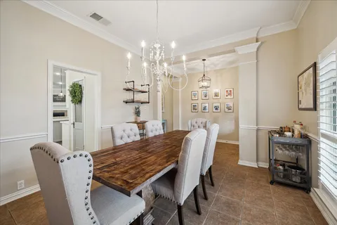 a kitchen with kitchen island a dining table chairs stainless steel appliances and cabinets