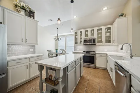 a large kitchen with kitchen island a table and chairs