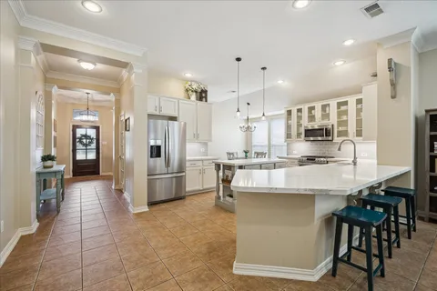 a large kitchen with stainless steel appliances lots of counter space and windows