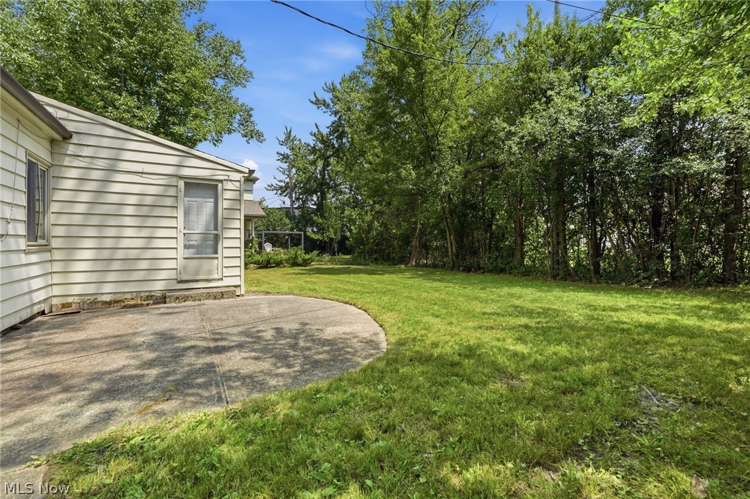 2537 Edgewood Road Beachwood, OH 44122 - Photo 39 of 39 Expansive backyard featuring a large green lawn, mature trees creating a natural border, and a curved concrete patio extending from the property