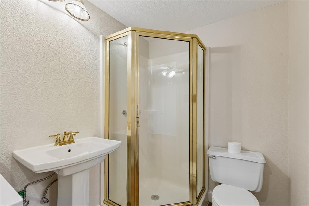 4 Eastshore Road Heath, TX 75032 - Photo 24 of 37 a bathroom with a sink mirror toilet and shower
