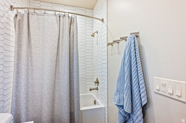 3 Carriagewood Cove, Unit 1088 Sandy, UT 84092 - Photo 37 of 79 Bathroom featuring a white subway tile pattern in a vertical orientation, a white bathtub with a bronze finish shower head and faucet, and a curved shower curtain rod