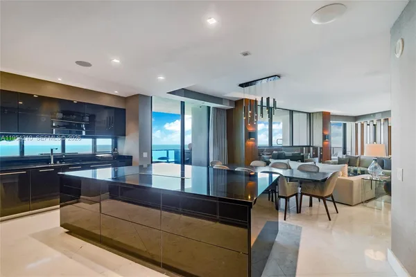 a living room with lots of furniture and view of kitchen
