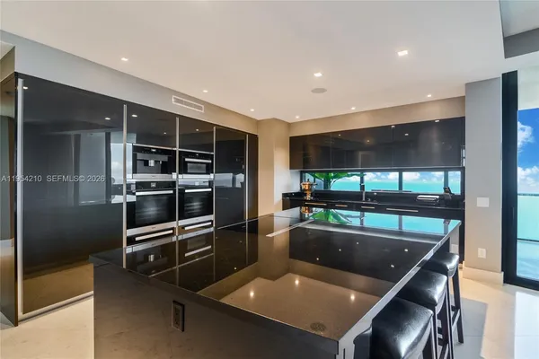 a kitchen with stainless steel appliances granite countertop a sink and a refrigerator