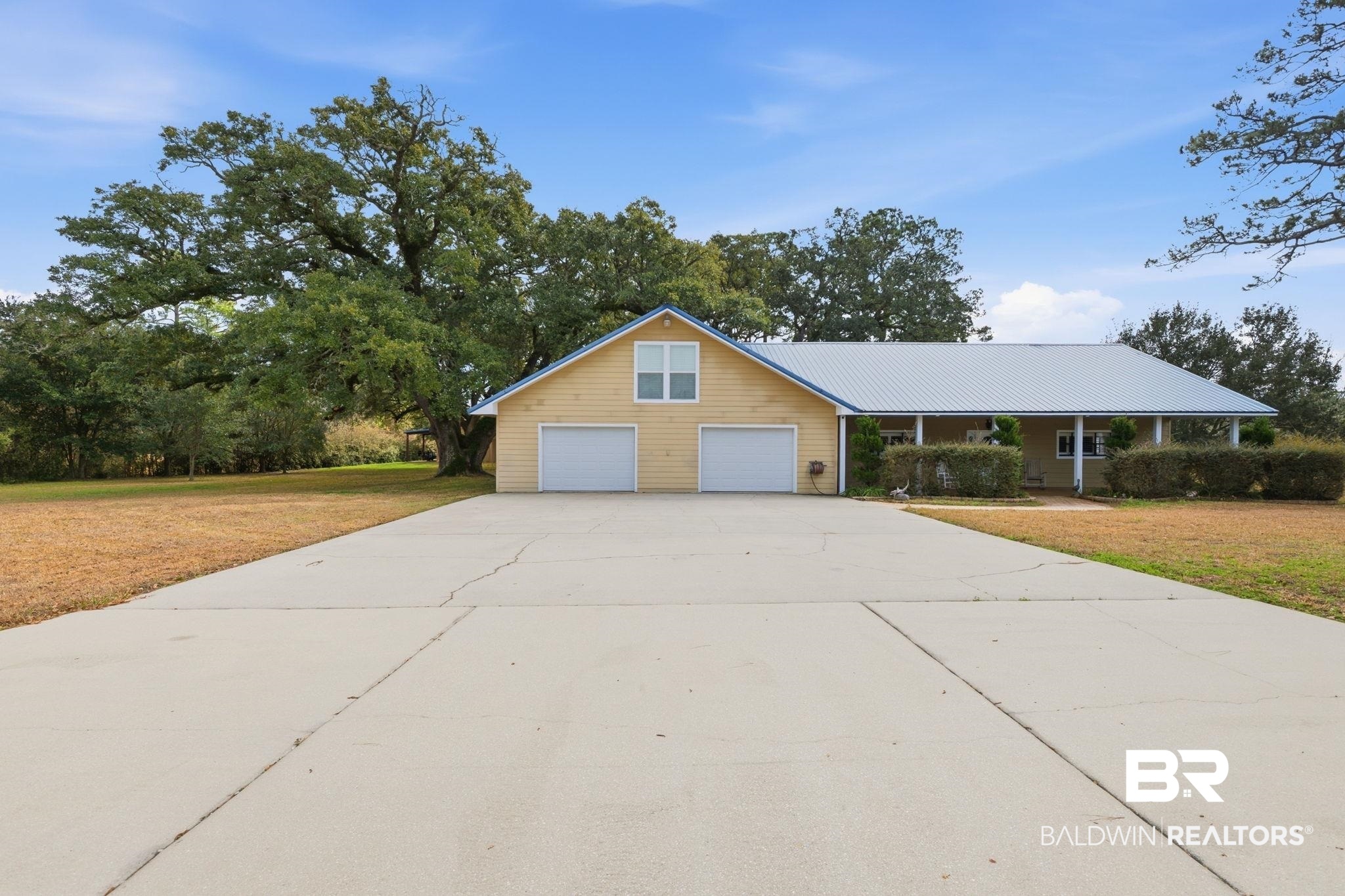 15025 Bellingrath Road Coden, AL 36523 - Photo 2 of 79 View of front of house with a front yard, concrete driveway, and a metal roof