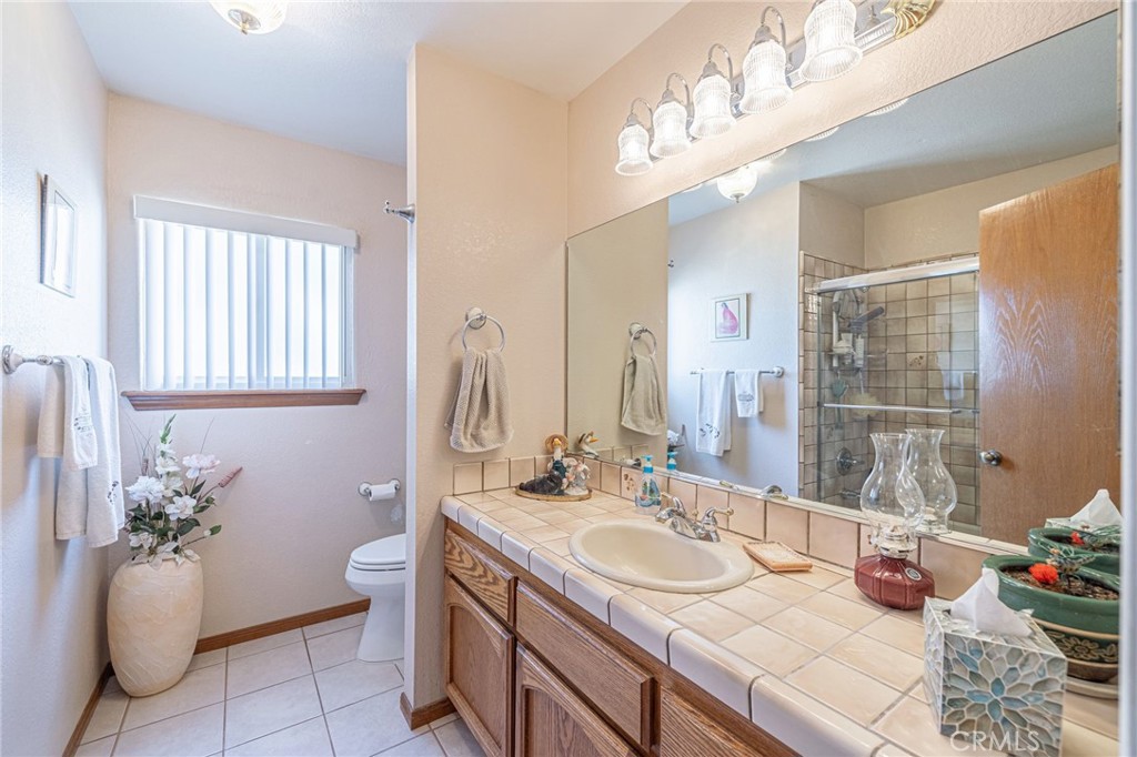 8541 West Ave D Lancaster, CA 93536 - Photo 21 of 62 a bathroom with a granite countertop sink a large mirror and a shower