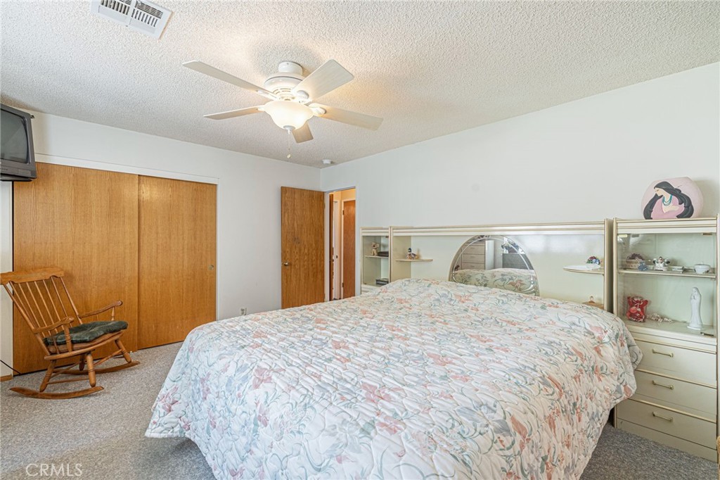 8541 West Ave D Lancaster, CA 93536 - Photo 24 of 62 a bedroom with a bed and a chandelier