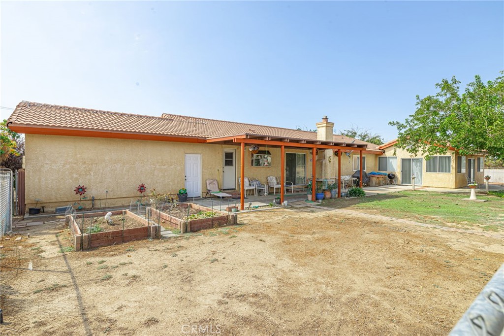 8541 West Ave D Lancaster, CA 93536 - Photo 42 of 62 a row of chairs and a table in the patio of a house