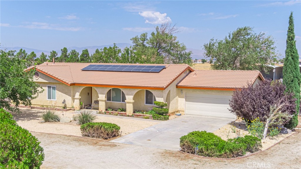 8541 West Ave D Lancaster, CA 93536 - Photo 45 of 62 a view of a white house with a yard and plants