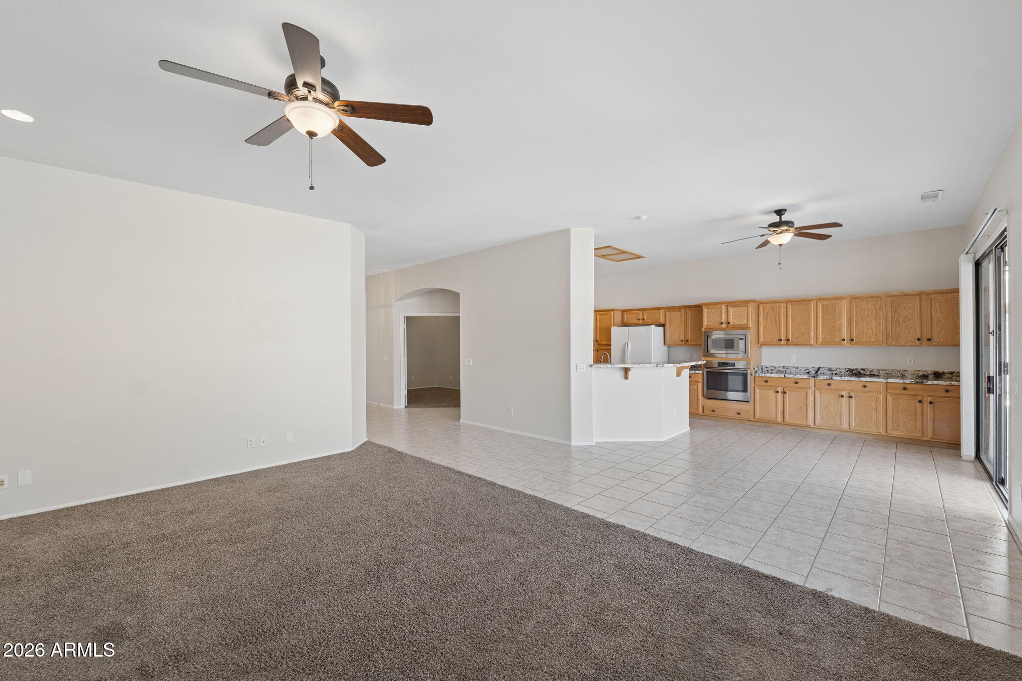 4418 East Jaeger Road Phoenix, AZ 85050 - Photo 7 of 42 a view of a livingroom with a ceiling fan a ceiling fan and kitchen view