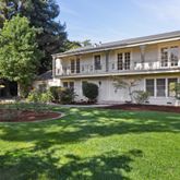a view of a house with a yard and potted plants