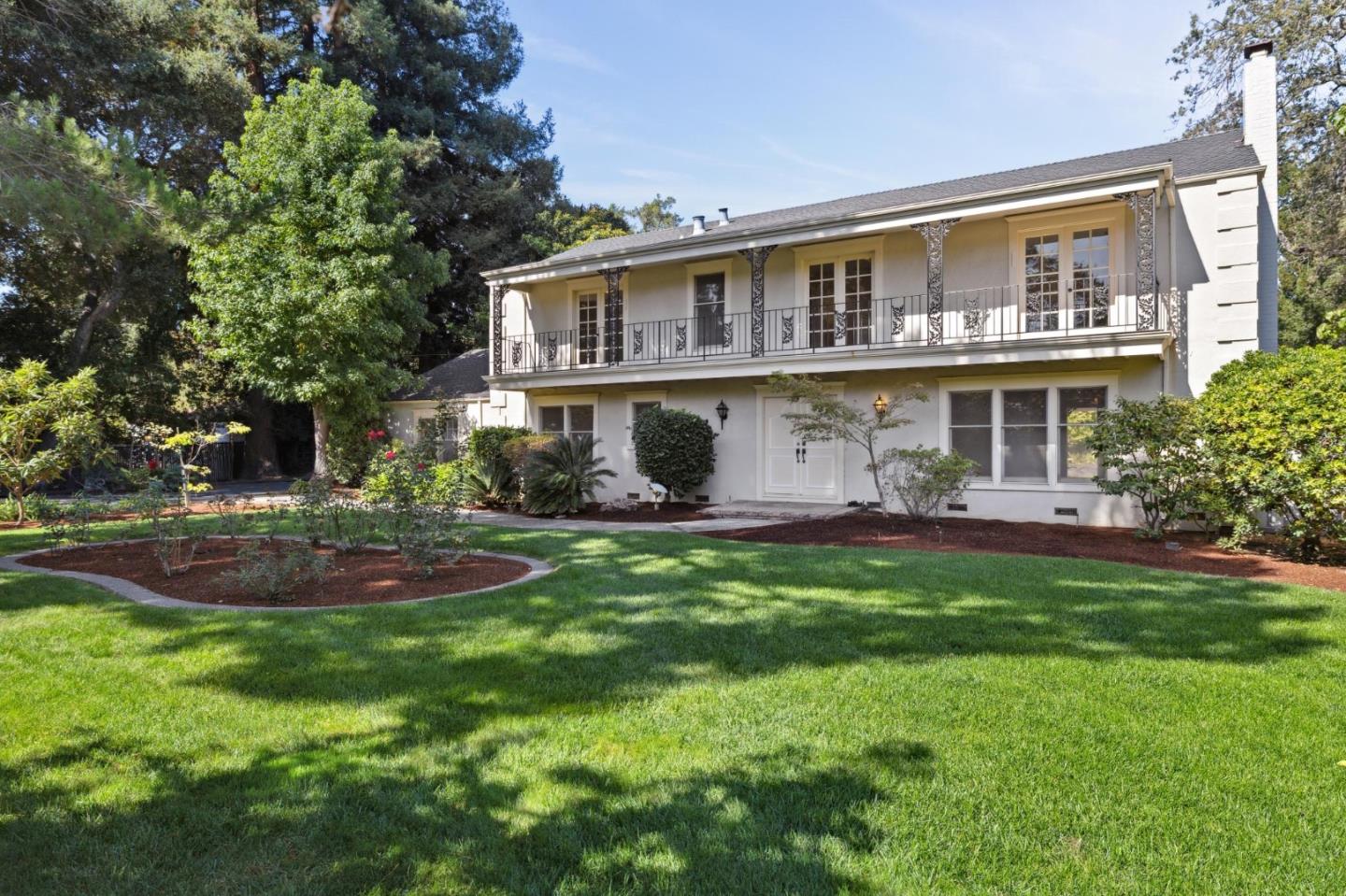 a view of a house with a yard and potted plants